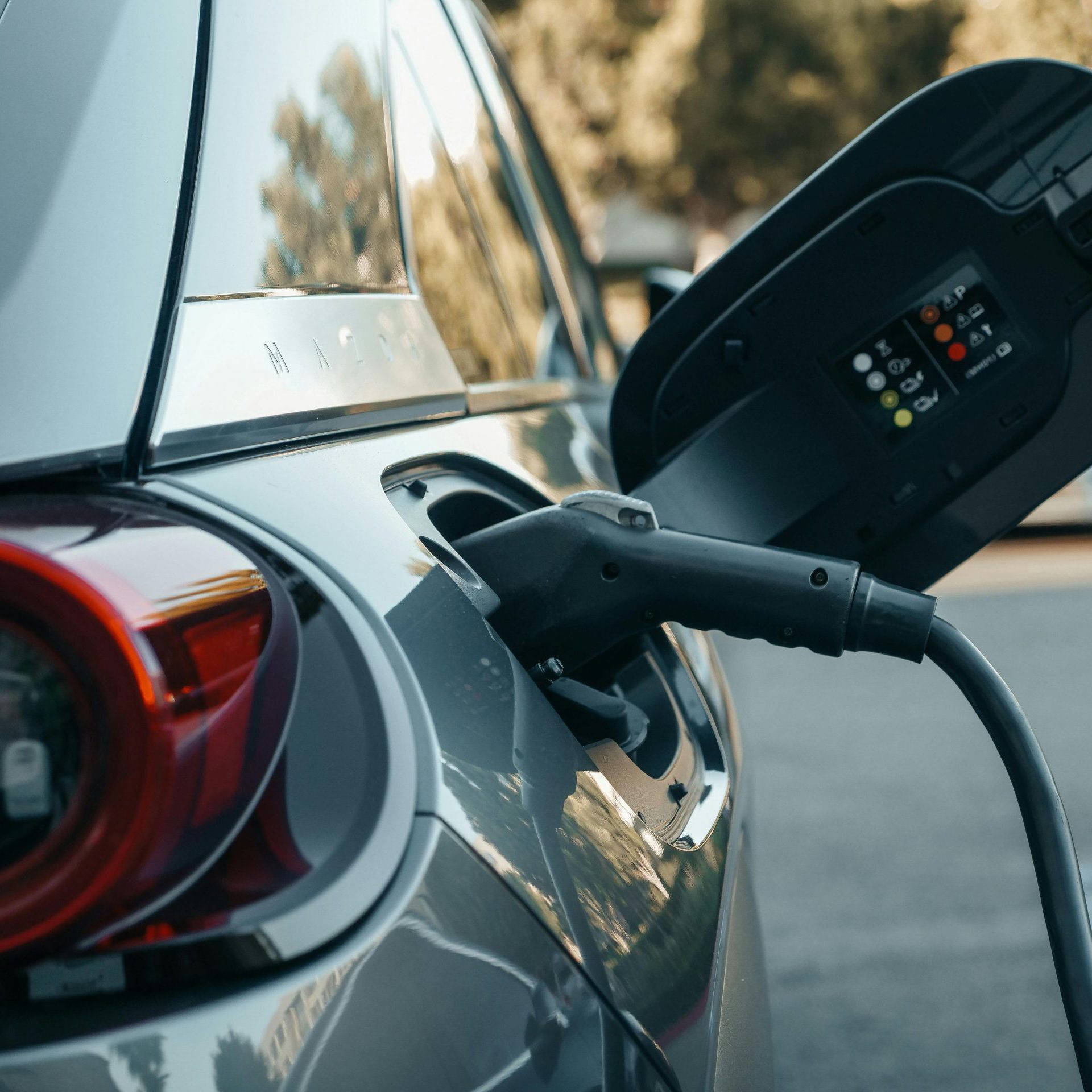 Close-up of an electric vehicle being charged, highlighting modern clean energy technology.